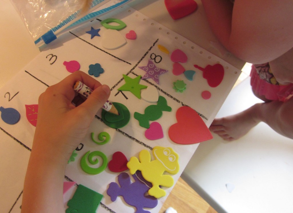 child counting items in a box on a piece of paper