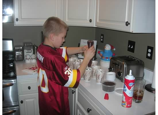 boy putting chocolate on hot cocoa