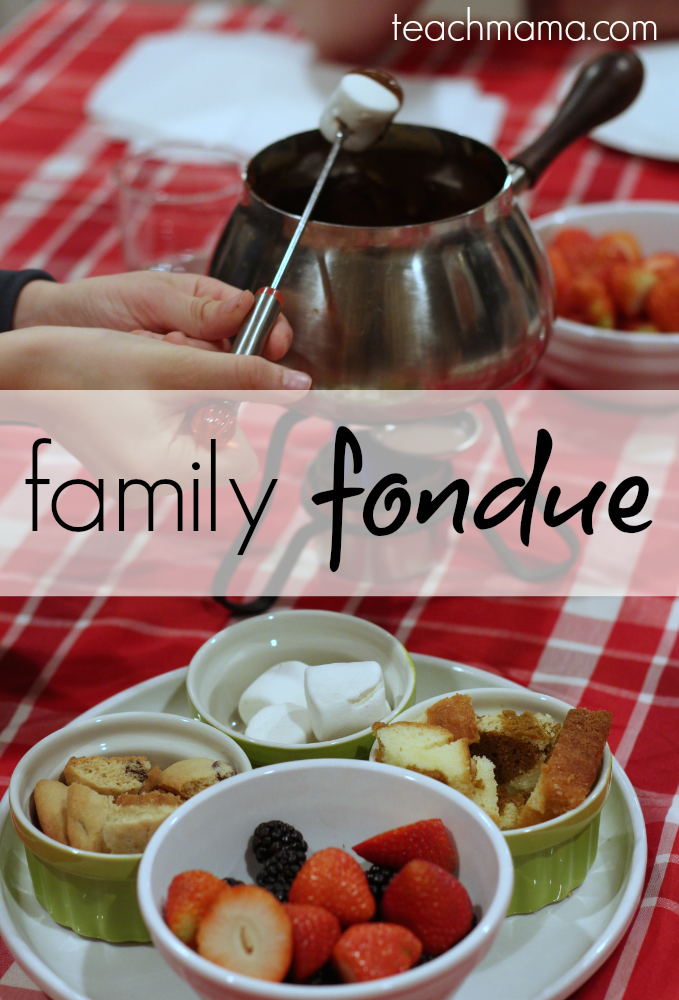 fruit, cookies, and marshmallows next to a fondue set 