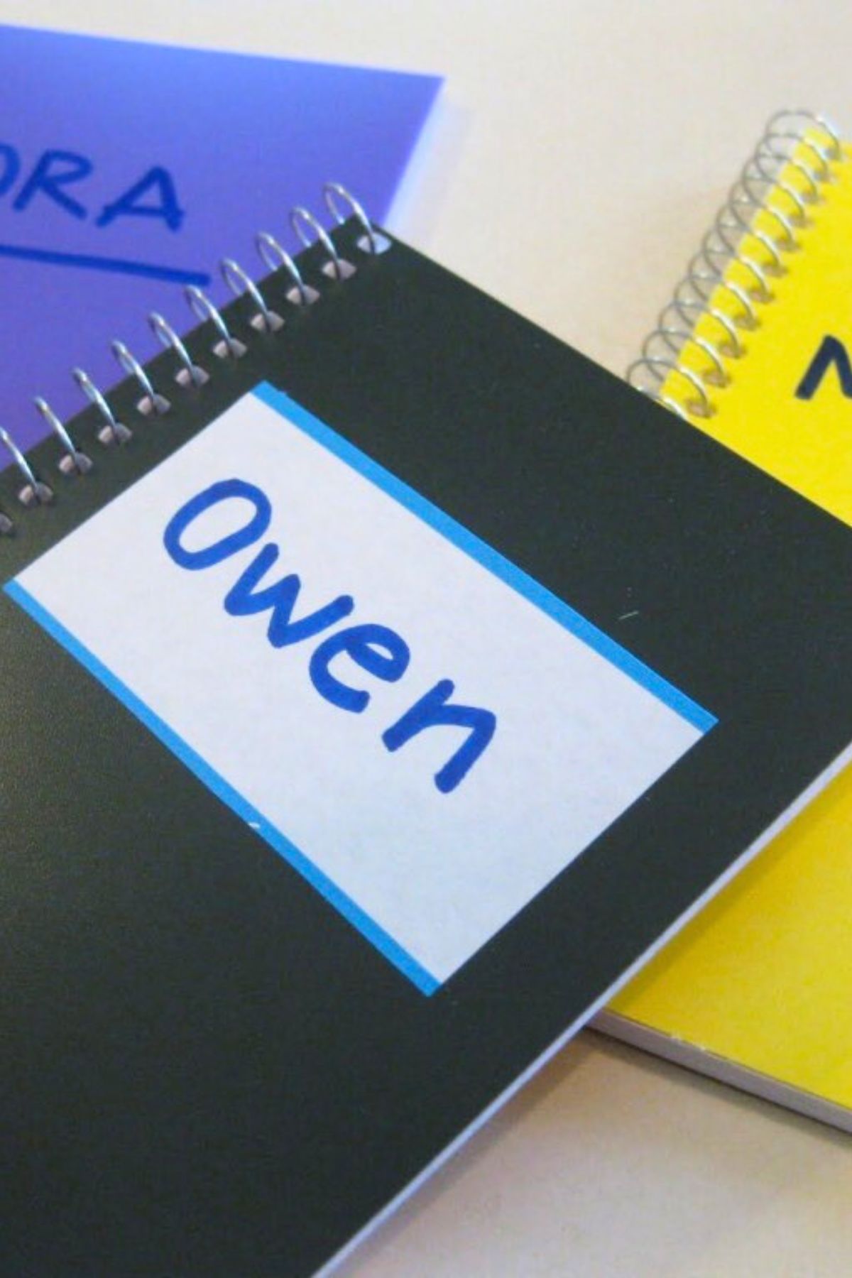 Black spiral notebook with a name tag on front