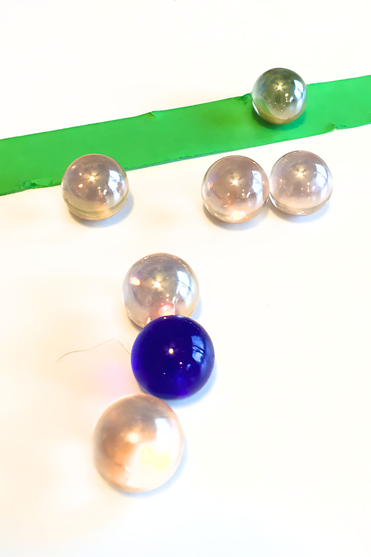 Blue and clear glass balls on a table with a strip of double-side tape