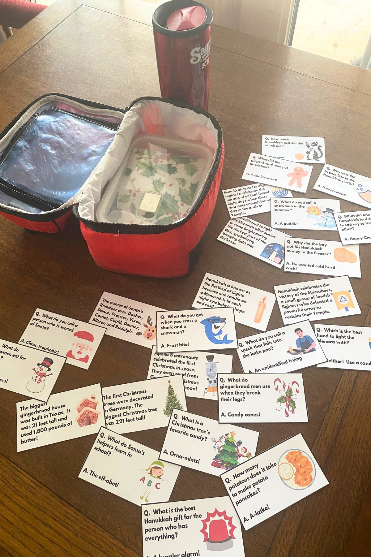 Holiday Fun Fact Lunchbox notes on a wooden table next to a red lunch pail