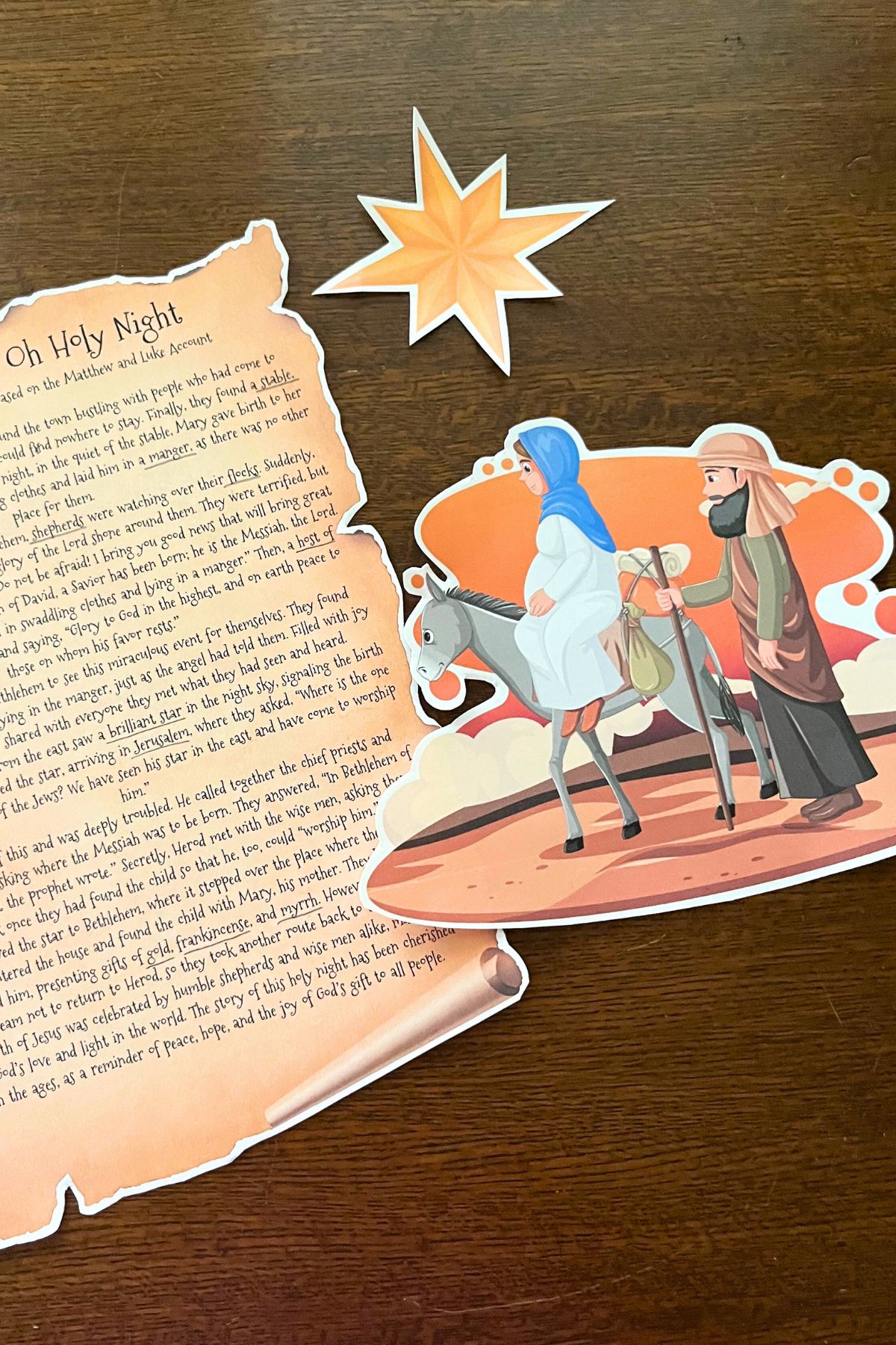 Printed Christmas story, star and the holy family on a wooden background