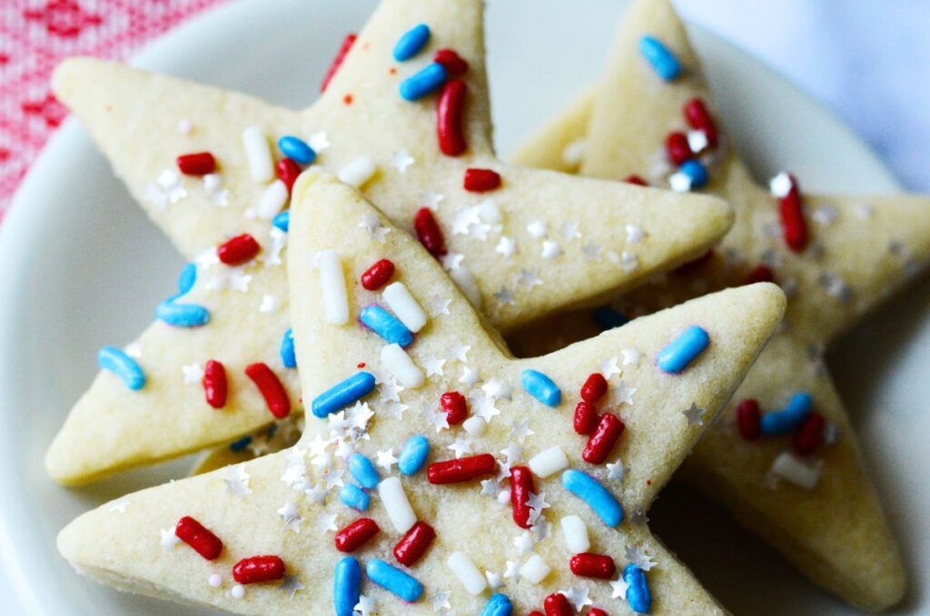 Star-shaped sugar cookies with red and white and blue sprinkles.