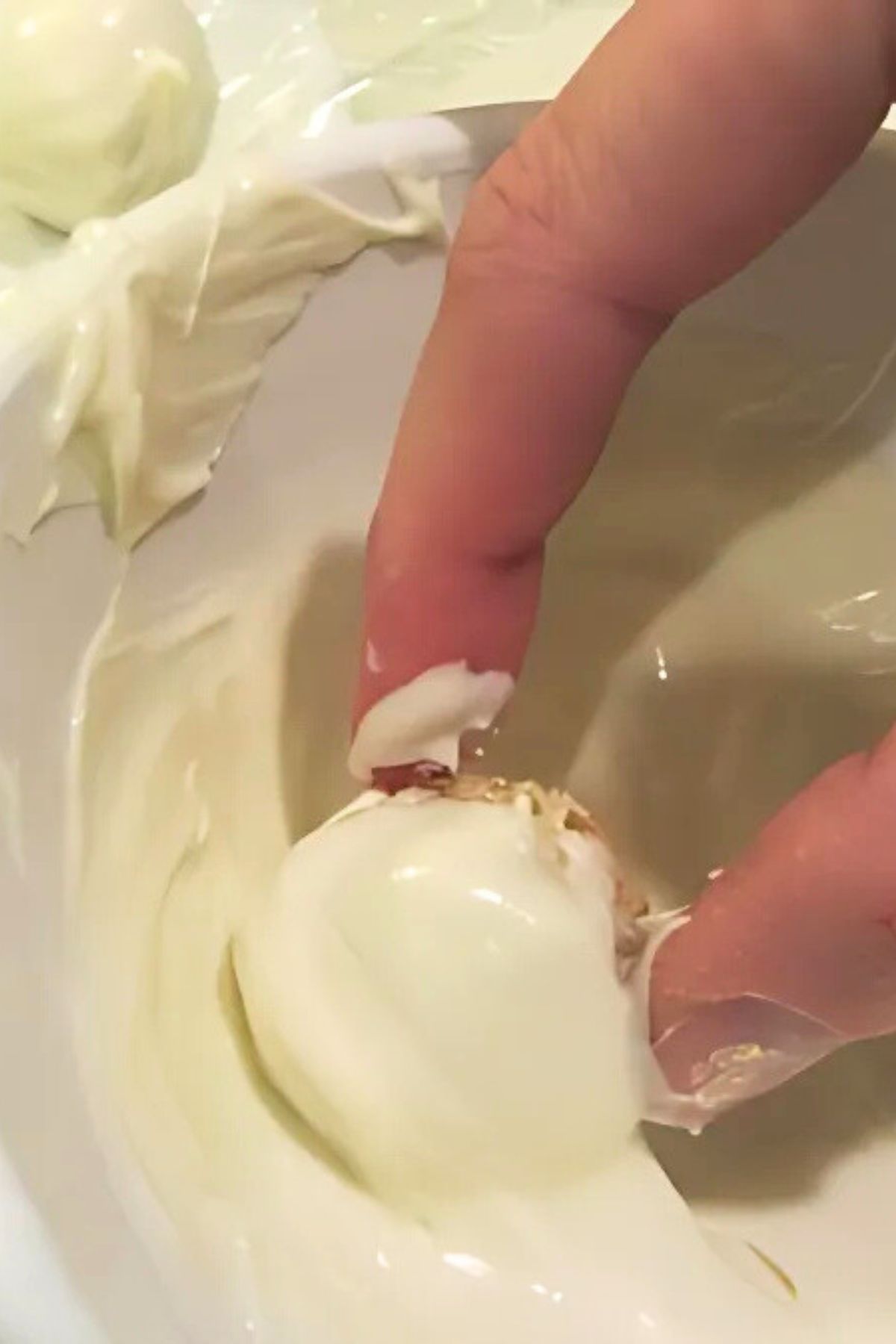 Rolling the Rice Krispy balls in melted white chocolate