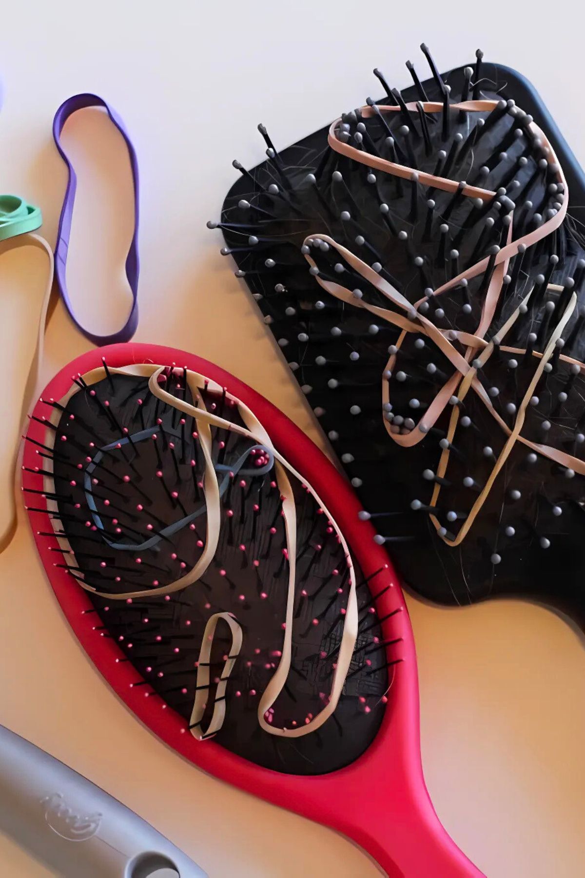 Hair brushes with rubber bands woven among the bristles