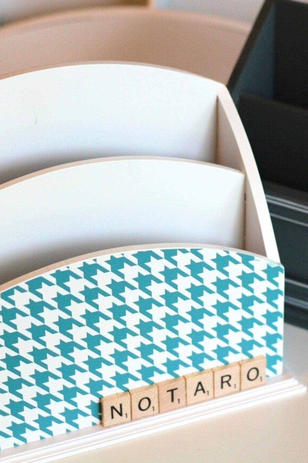 Wooden file holder with a blue and white front and Scrabble tiles spelling out a last name