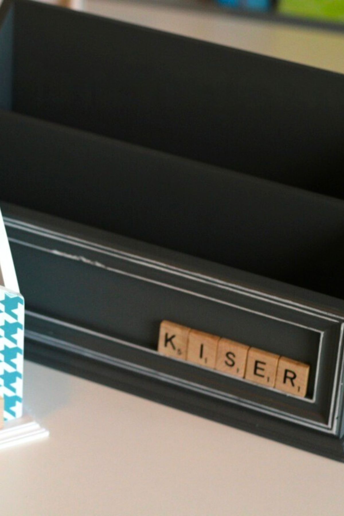 Black wooden file holder with Scrabble tile spelling a last name