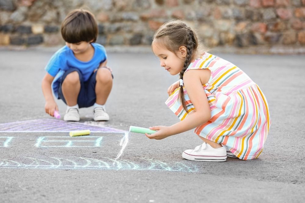 Kids playing Chalk in the sidewalk