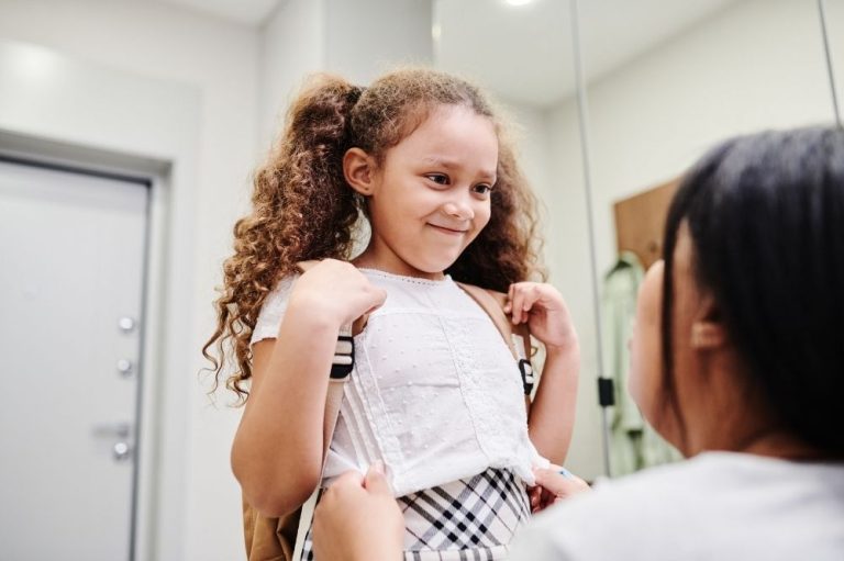 A young girl with curly hair ready for school