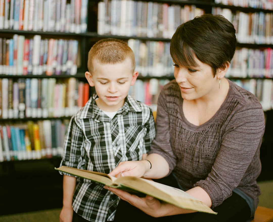 Mother smiling at her daughter, who is holding a book and wearing a backpack