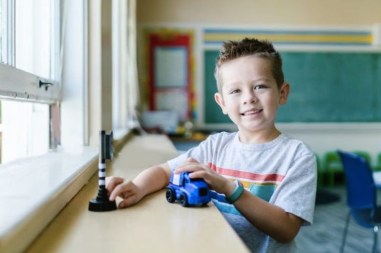 young boy inside the classroom playing